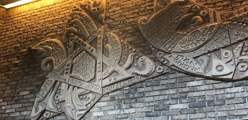 A picture containing text, building, brick, stone Description automatically generated